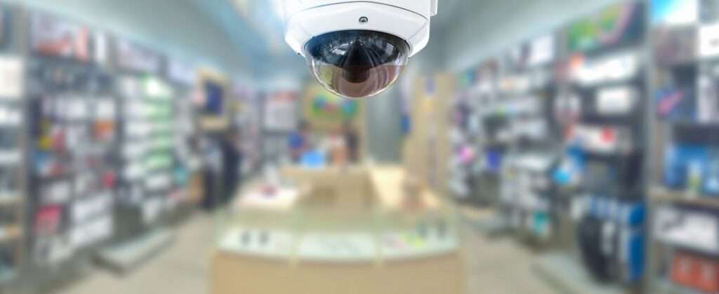 The Top Security Measures For Commercial Properties 4 CCTV security panorama with shop store blurry background.